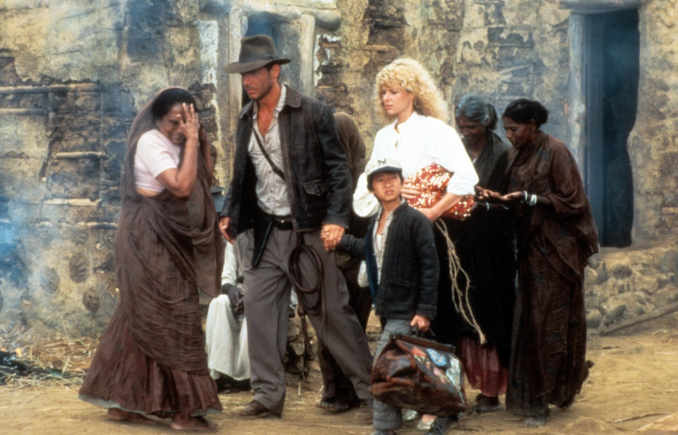 Harrison Ford, Jonathan Ke Quan and Kate Capshaw are lead through a temple in a scene from the film 'Indiana Jones And The Temple Of Doom', 1984. (Photo by Paramount/Getty Images)