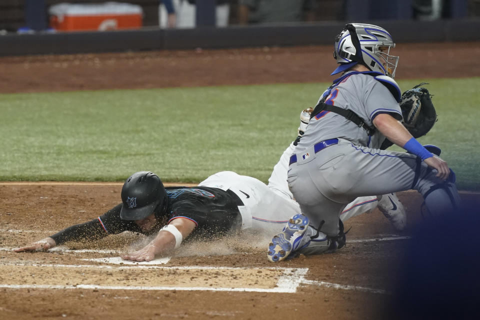 Miami Marlins' Nick Fortes (54) scores on a double by Miguel Rojas as New York Mets catcher Tomas Nido (3) is late with the tag during the fourth inning of a baseball game, Friday, Sept. 9, 2022, in Miami. (AP Photo/Marta Lavandier)