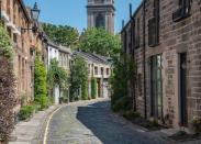 Set in the Stockbridge area of Edinburgh, Circus Lane is brimming with charm. The curved cobblestone street features terraced mews houses clad with climbing plants and accented with colorful window boxes.