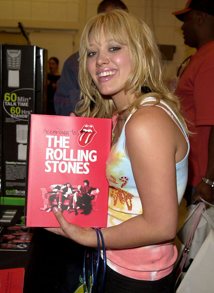 Hilary holding a book called "According to the Rolling Stones"