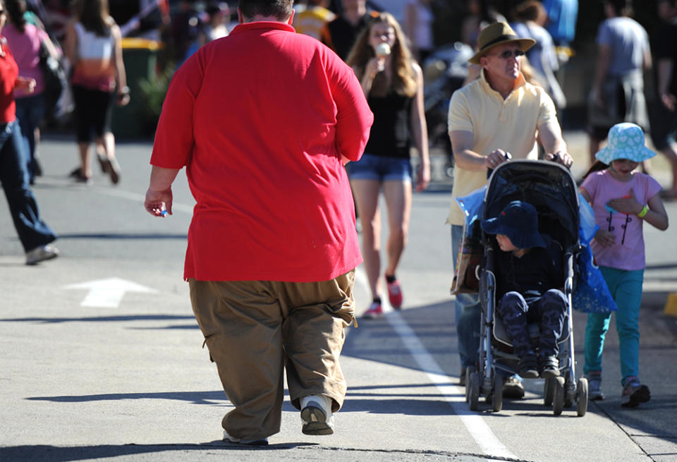 An overweight man walks through Brisbane, Monday, Aug. 12, 2013. 