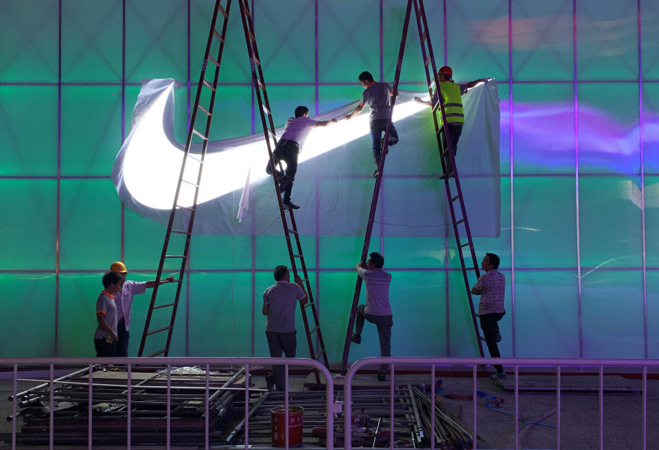 Workers install a Nike logo lamp outside the Wukesong Arena in Beijing, China August 28, 2019. Picture taken August 28, 2019. REUTERS/Tingshu Wang