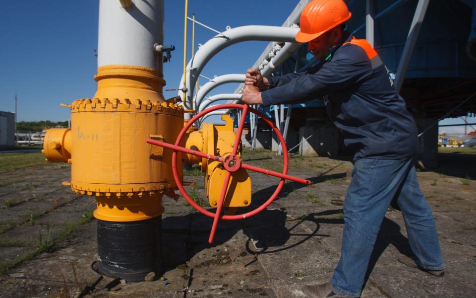 A worker tightens the valve on a pipeline at an underground gas storage facility in Ukraine - AFP