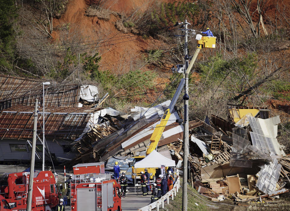 Rescuers work at the site of a landslide in Tsuruoka, Yamagata prefecture, north of Tokyo Saturday, Dec. 31, 2022. A landslide swallowed about a dozen homes in northern Japan Saturday. (Kyodo News via AP)