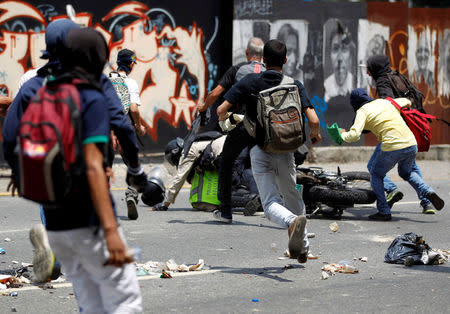 Demonstrators grab a riot police officer at a rally against Venezuela's President Nicolas Maduro's government in Caracas, Venezuela April 10, 2017. REUTERS/Christian Veron