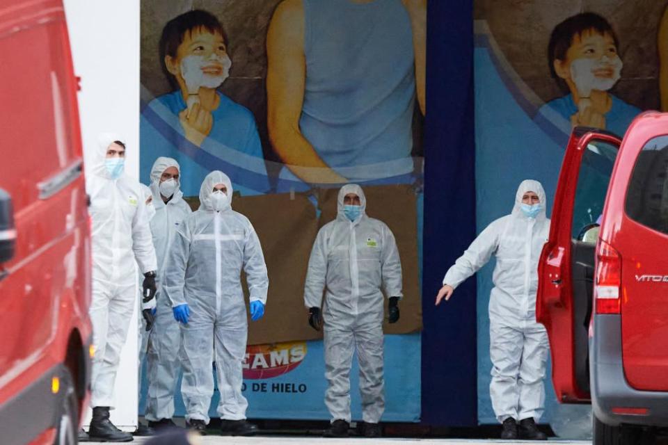 Members of the Military Emergency Unit wait for vans of deceased people for cold storage at the Palacio de Hielo ice rink in Madrid, Spain, on 24 March.