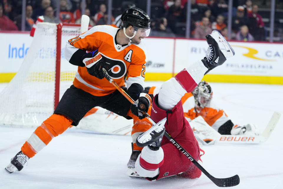 Philadelphia Flyers' Scott Laughton, left, collides with Detroit Red Wings' Jake Walman during the first period of an NHL hockey game, Sunday, March 5, 2023, in Philadelphia. (AP Photo/Matt Slocum)