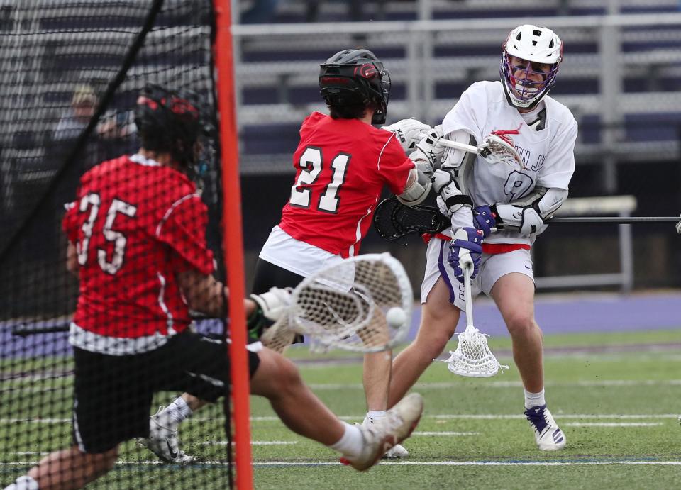 John Jay's Bryce Ford (9) fires a shot that is stooped by Rye goalie Emmet Carroll (35) during boys lacrosse action at John Jay High School in Cross River March 29, 2019. John Jay won the game 8-6.