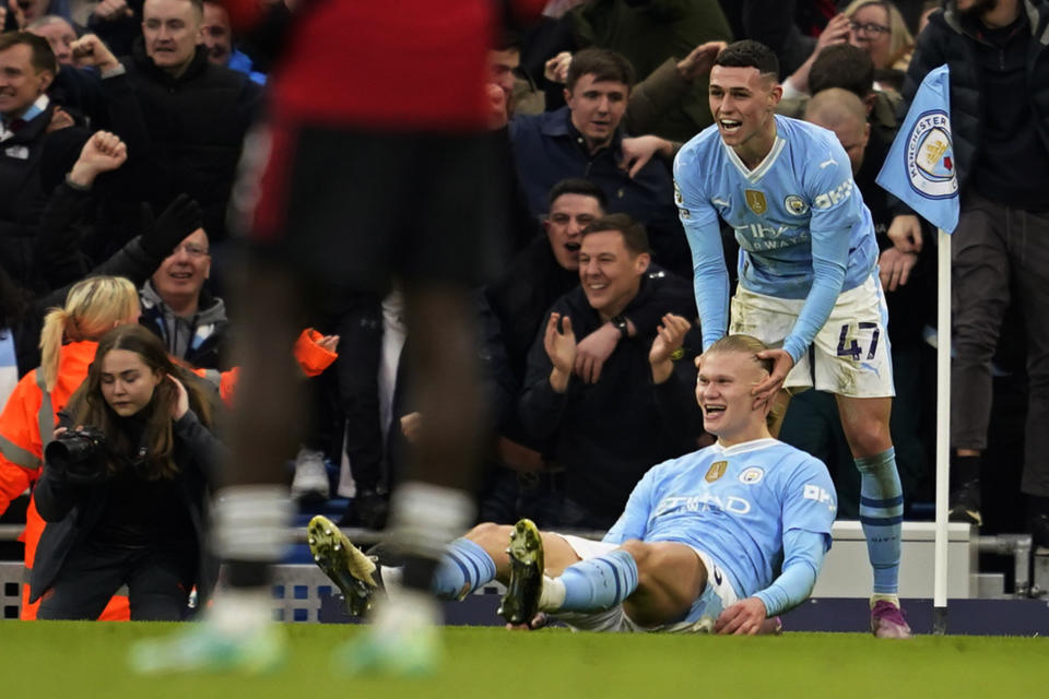 Manchester City's Erling Haaland celebrates with Phil Foden, right, after scoring his side's third goal during an English Premier League soccer match between Manchester City and Manchester United at the Etihad Stadium in Manchester, England, Sunday, March 3, 2024. (AP Photo/Dave Thompson)