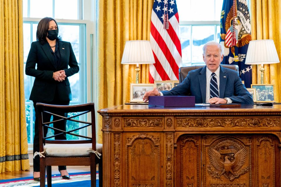 President Joe Biden, accompanied by Vice President Kamala Harris, looks up after signing the American Rescue Plan.