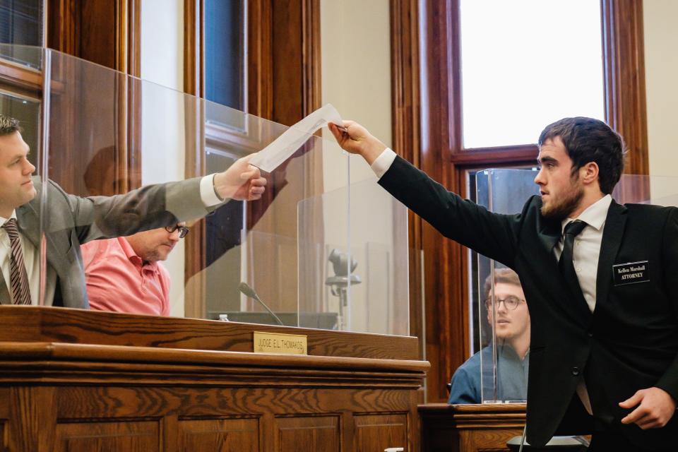 Kellen Marshall, a senior from Steubenville High School, hands paperwork to state Rep. Brett Hillyer (R-Uhrichsville) during the regional competition of the 40th annual Ohio High School Mock Trial Competition held recently at the Tuscarawas County Courthouse. Hillyer is a practicing attorney in Tuscarawas County. Steubenville was competing against New Philadelphia in Judge Elizabeth Lehigh Thomakos' courtroom while other area schools competed in other courtrooms.