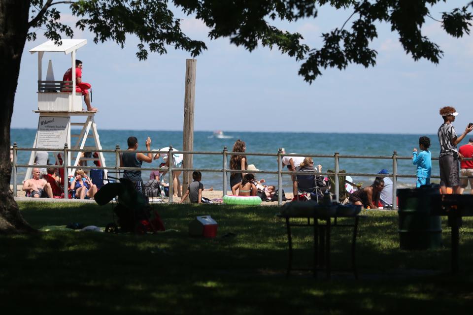 Sunbathers and swimmers celebrate the  Fourth of July at Ontario Beach Park in 2017.