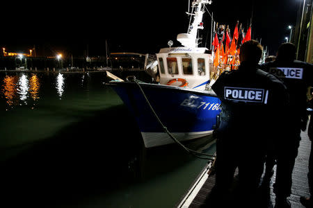 French policemen walk past trawlers, as they patrol the harbour in Boulogne-sur-Mer, France, January 11, 2019. Picture taken January 11, 2019. REUTERS/Pascal Rossignol