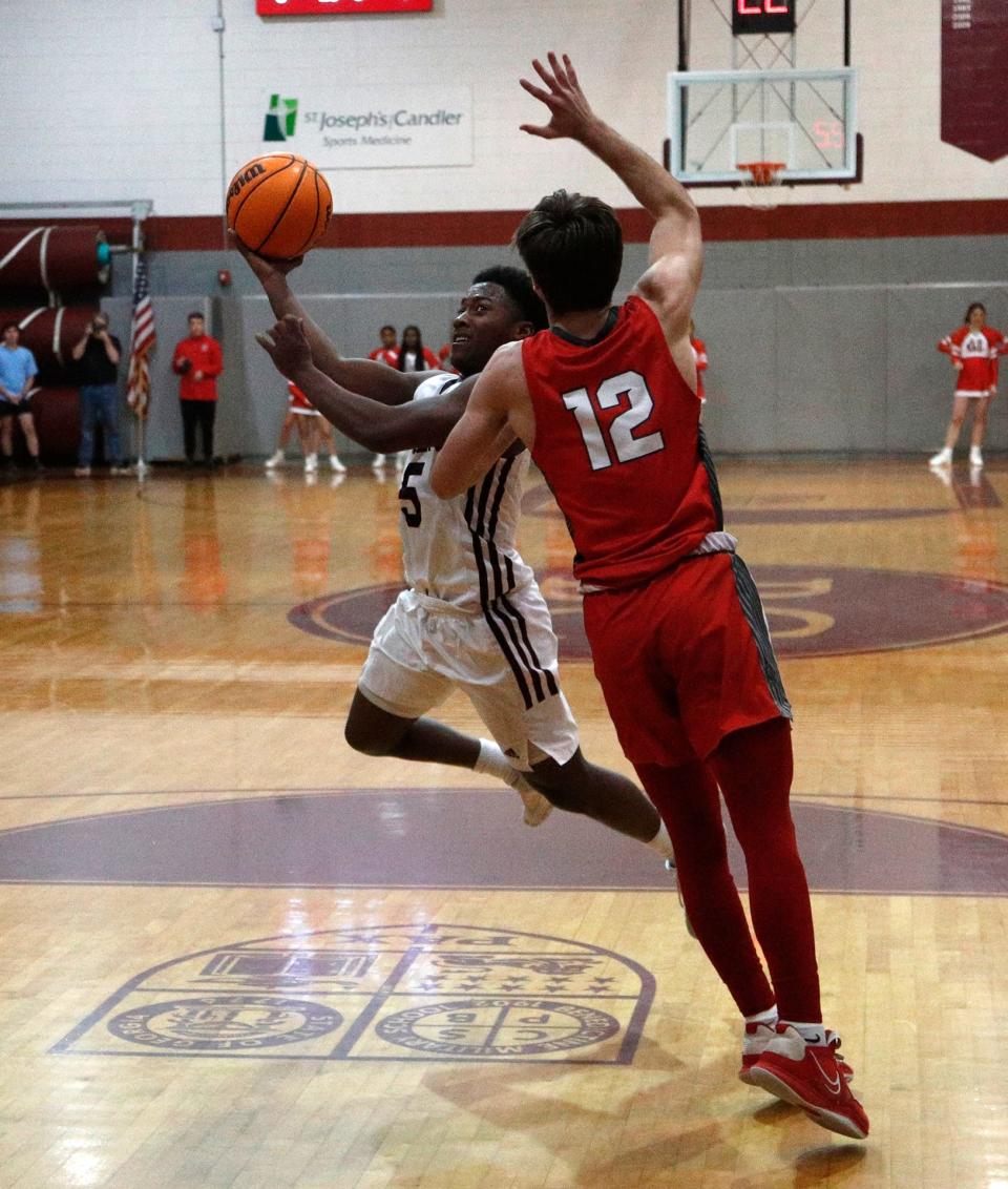 Benedictine's Stephon Frazier slices through the lane against Madison County's Kyle Pruitt during the Class 4A quarterfinals on Wednesday March 1, 2023.