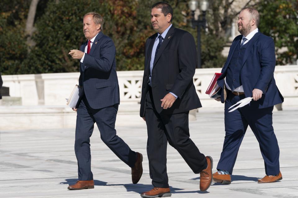 Texas Attorney General Ken Paxton, left, and Texas Solicitor General Judd Stone, far right, leave the Supreme Court, Monday, Nov. 1, 2021, after justices heard three hours of arguments in two cases over whether abortion providers or the Justice Department can mount federal court challenges to the law, which has an unusual enforcement scheme its defenders argue shields it from federal court review, on Capitol Hill in Washington. (AP Photo/Jacquelyn Martin)