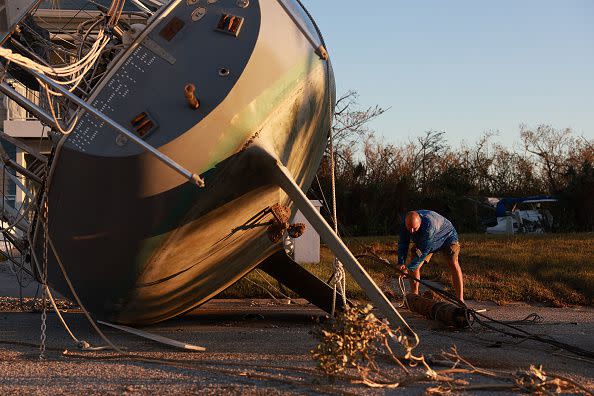 FORT MYERS, FLORIDA - SEPTEMBER 30: Ron Waselenchuk inspects his sailboat which was pushed ashore by hurricane Ian on September 30, 2022 in Fort Myers, Florida. The hurricane brought high winds, storm surge and rain to the area causing severe damage. (Photo by Joe Raedle/Getty Images)