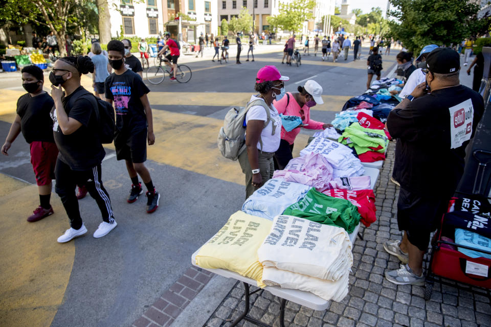 A man sells shirts on 16th Street, Monday, June 8, 2020, near the White House in Washington, after days of protest over the death of George Floyd, a black man who was in police custody in Minneapolis. Floyd died after being restrained by Minneapolis police officers. (AP Photo/Andrew Harnik)