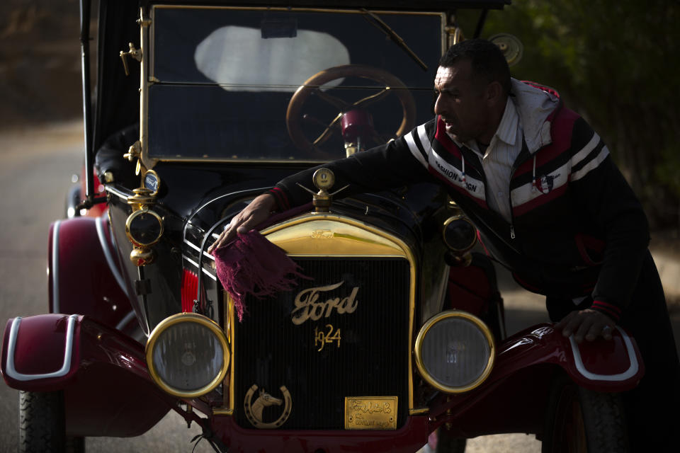 A mechanic wipes a 1924 Ford T in Obour, near Cairo, Egypt, Tuesday, March 1, 2022. The car once belonged to Egypt's King Farouk's and is a part of over 250 vintage, antique and classic cars fleet Egyptian bussinesman Mohamed Wahdan collected over the past 20 years. (AP Photo/Amr Nabil)