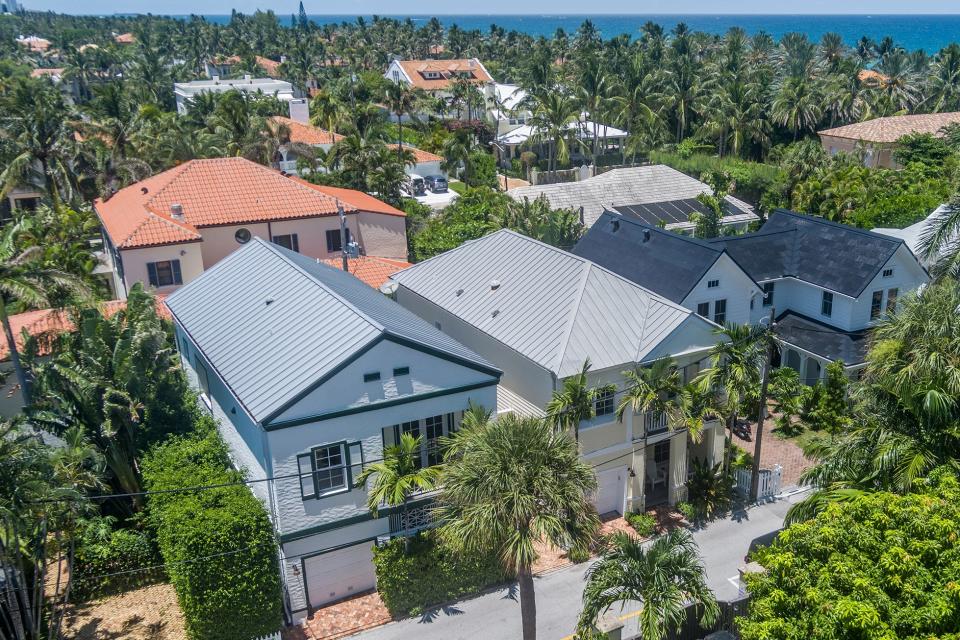 The late singer and businessman Jimmy Buffett's ownership company bought these two side-by-side two-story houses, foreground, in 2013 in Palm Beach. Priced at $6.125 million, the house addressed as 138B Root Trail is at the far left. The one next door is known as 135A Root Trail and is priced at $6.65 million.