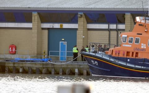 Authorities waiting next to a blue tarpaulin at Grimsby docks - Credit: MEN Media