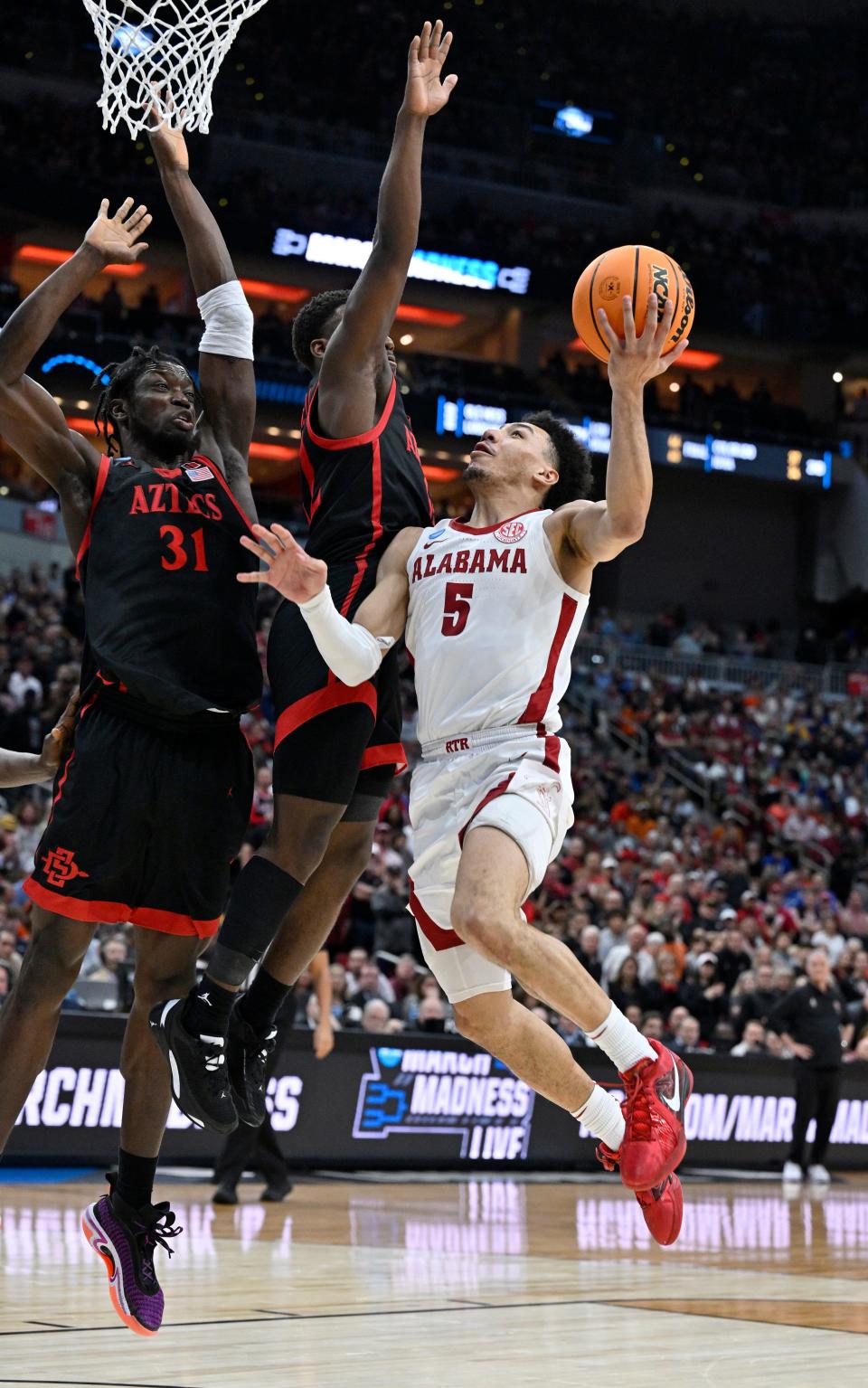 Alabama Crimson Tide guard Jahvon Quinerly (5) shoots against San Diego State Aztecs forward Nathan Mensah (31) and guard Darrion Trammell (12) during the second half of the March 24 NCAA Tournament Round of 16 at KFC YUM! Center in Louisville, Ky.