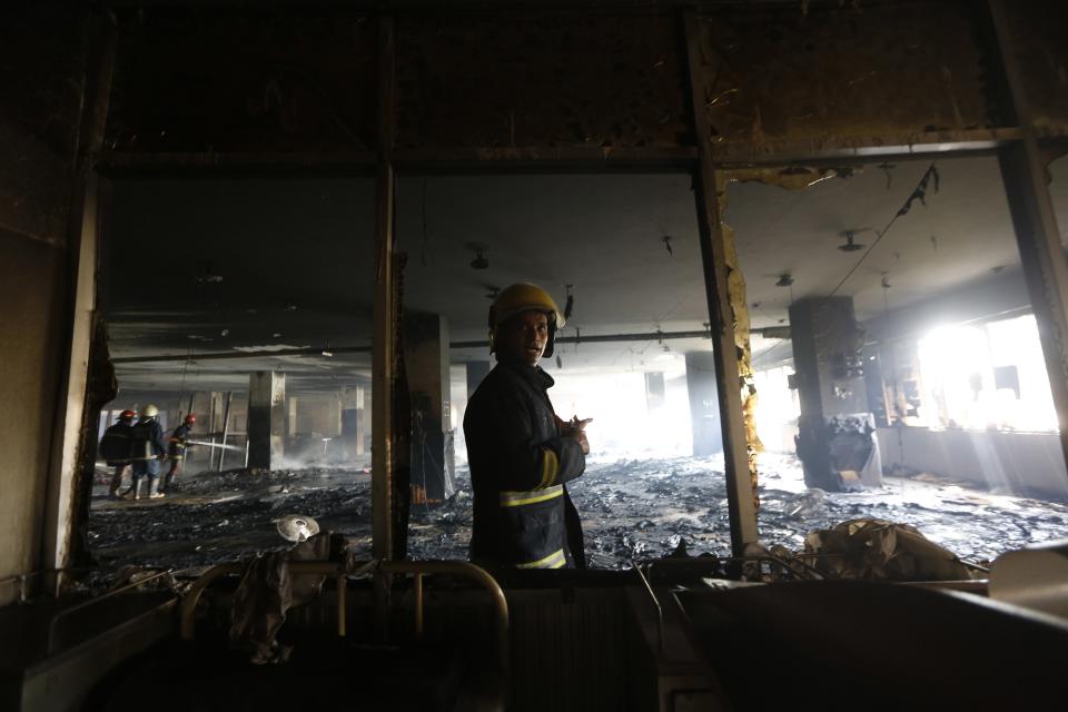 A firefighter inspects the damage at a Standard Group garment factory which was on fire in Gazipur