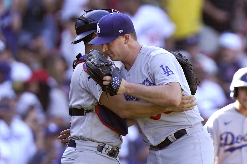 Los Angeles Dodgers catcher Austin Barnes, behind left, celebrates with pitcher Evan Phillips, right, after the Dodgers beat the Boston Red Sox in a baseball game, Sunday, Aug. 27, 2023, in Boston. (AP Photo/Steven Senne)