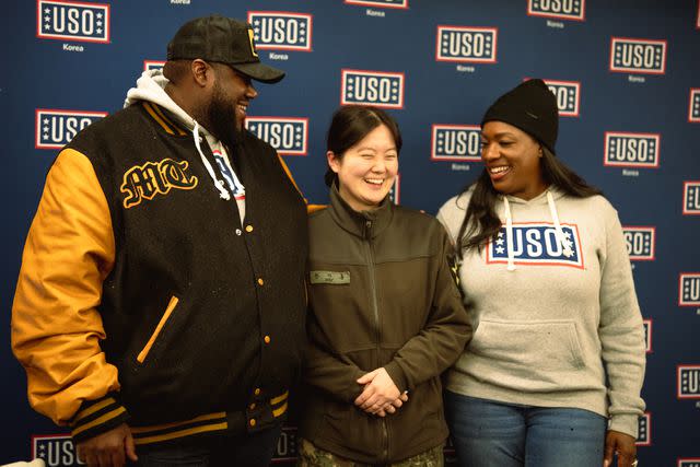 <p>Ethan Harney for the USO</p> Michael Trotter Jr. and Tanya Trotter with a U.S. service member