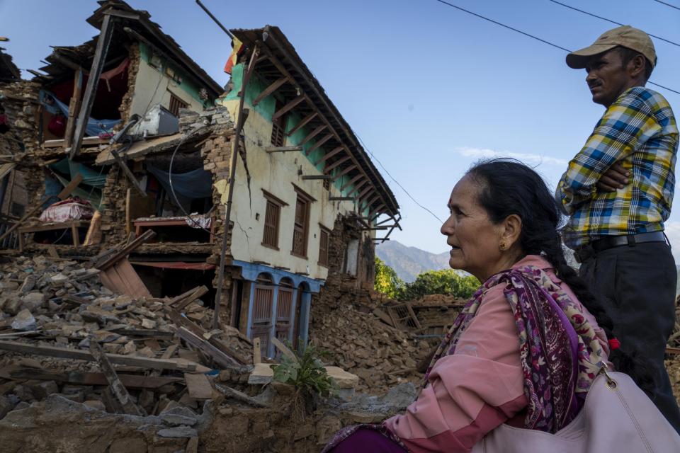 A woman sits in front of her earthquake damaged house in Jajarkot district, northwestern Nepal, Sunday, Nov. 5, 2023. (AP Photo/Niranjan Shrestha)