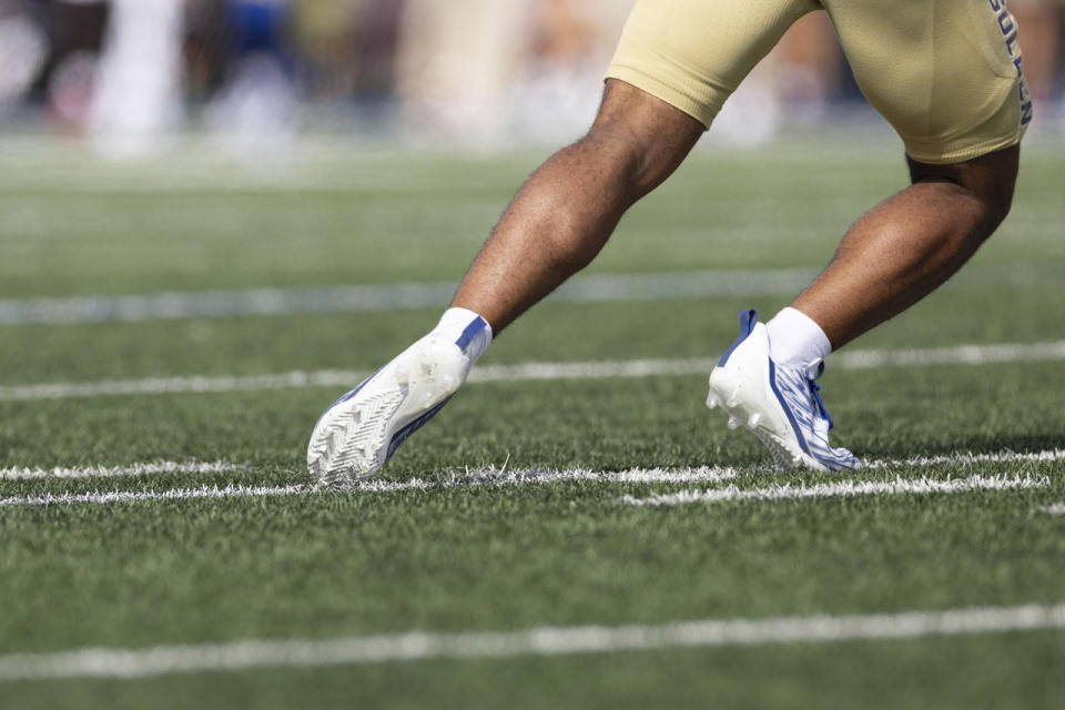 A Tulsa player runs on artificial turf during the team's NCAA college football game against Oklahoma in Tulsa, Okla., Sept. 18, 2023. These days, the soft plastic grass surfaces often look and feel like the real thing. The quality of the surfaces has advanced so much that many stadiums used by professional and college football teams have decided it is the better option. (AP Photo/Alonzo Adams)