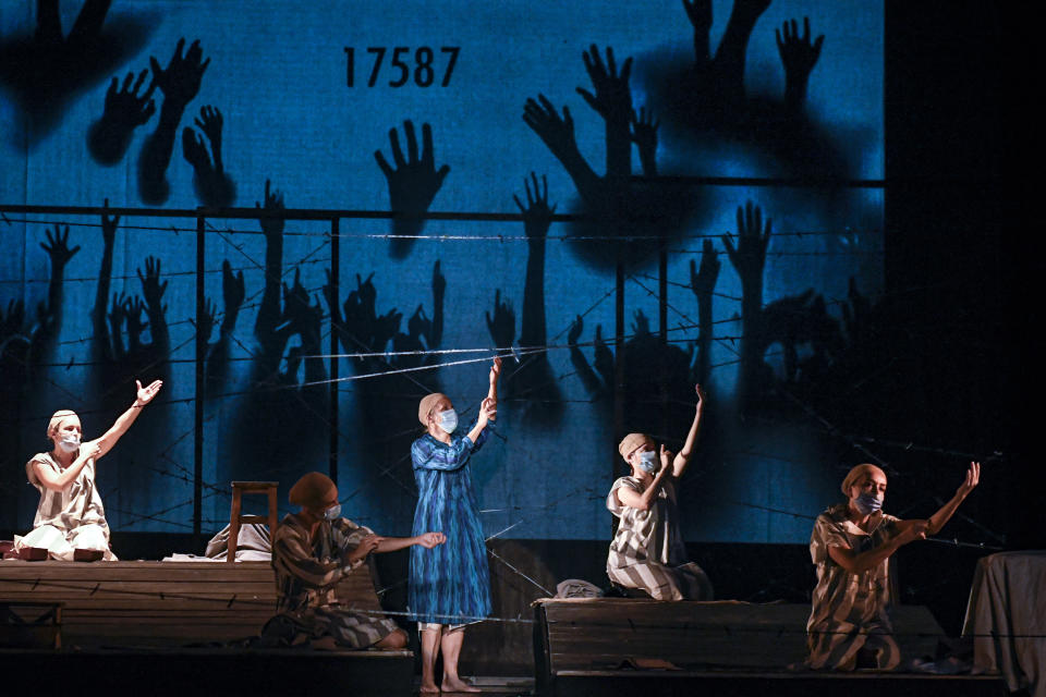 Actresses of the Jewish State Theatre, wearing face masks for protection against the COVID-19 infection, perform during the rehearsals for the premiere of the "The Beautiful Days of My Youth" play, based on the diary of Romanian Jewish Holocaust survivor Ana Novac, in Bucharest, Thursday, Oct. 15, 2020. Maia Morgenstern, head of the Jewish State Theater and a Romanian Jewish actress best known for playing Mary in Mel Gibson's controversial 2004 movie "The Passion of the Christ," described the play's staging in an interview with The Associated Press as an "all-feminine project." (AP Photo/Andreea Alexandru)