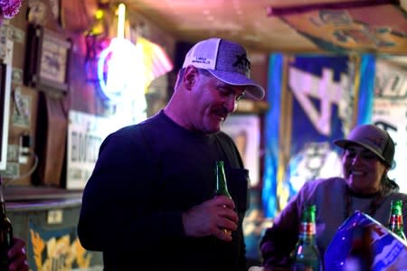 Co-workers Roy Cooper and Terri King enjoy a drink at The Field Office bar in Midland