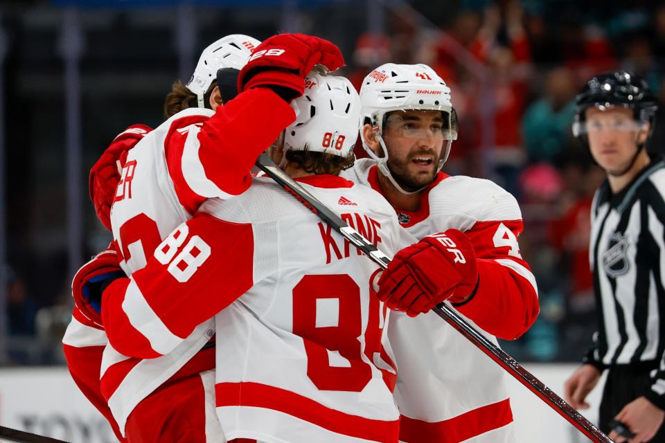 Red Wings defenseman Moritz Seider, left, celebrates with right wing Patrick Kane (88) and defenseman Shayne Gostisbehere after scoring a goal during the first period on Monday, Feb. 19, 2024, in Seattle.
