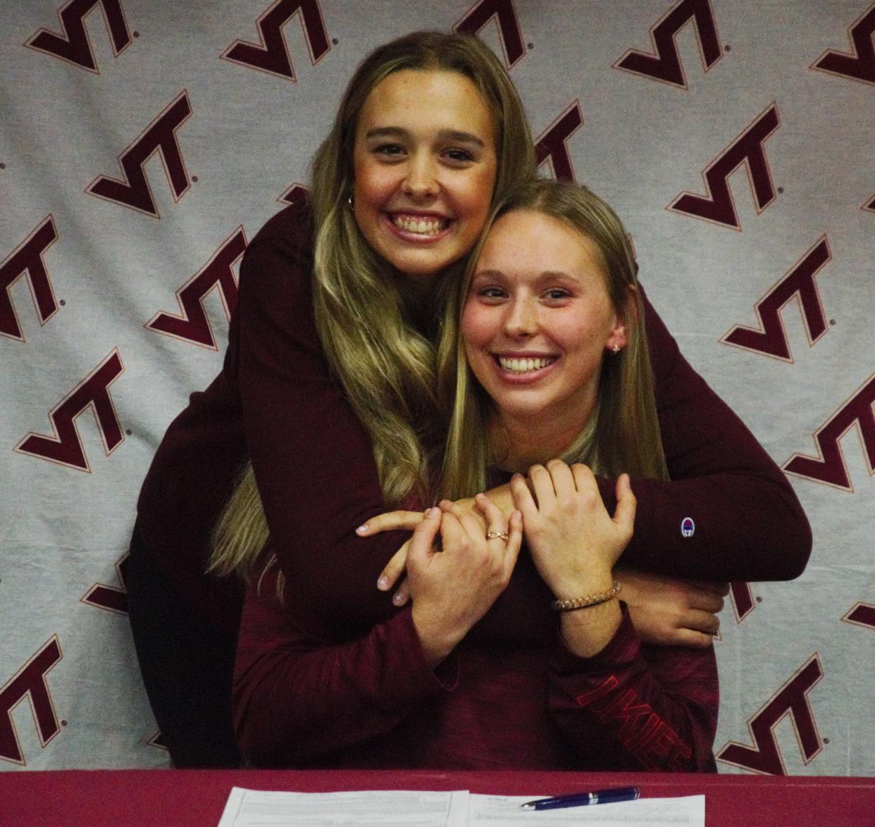 Jayden Jones (front) signs her letter of intent to play softball at Virginia Tech while her sister, OK State commit Aubrey Jones, supports her older sister.