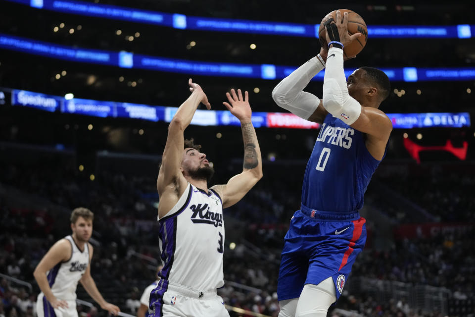 Los Angeles Clippers guard Russell Westbrook (0) shoots against Sacramento Kings guard Chris Duarte (3) during the second half of an NBA basketball game in Los Angeles, Tuesday, Dec. 12, 2023. (AP Photo/Ashley Landis)