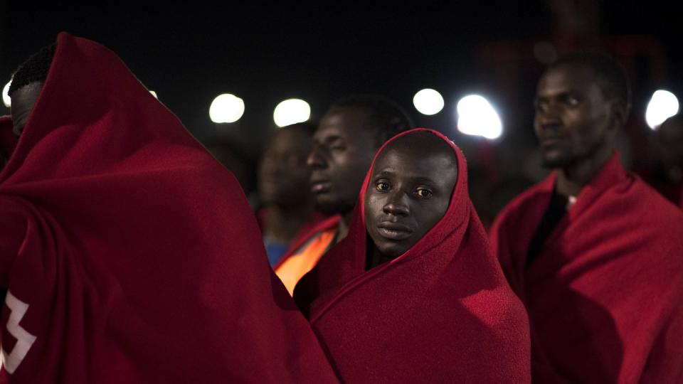 In Decken gehüllte geflüchtete Menschen aus Afrika warten darauf, vom Roten Kreuz in Spanien registriert zu werden. Foto: Carlos Gil, SOPA Images via ZUMA Wire