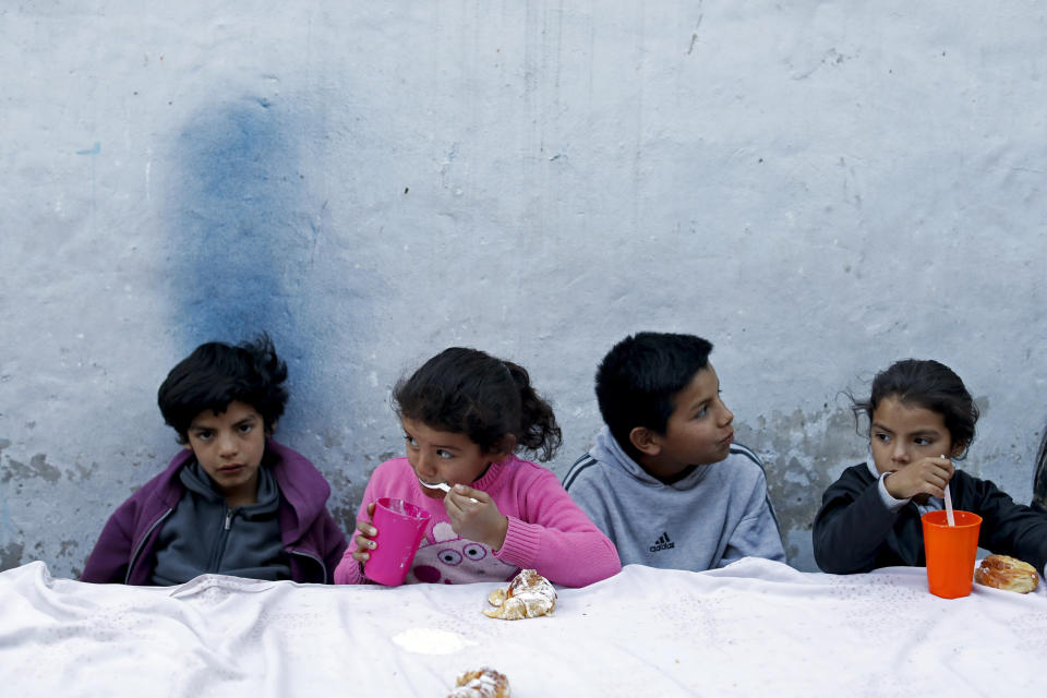 Children eat at a soup kitchen on the outskirts of Buenos Aires, Argentina, Tuesday, Sept. 17, 2019. Lawmakers passed a food emergency bill aimed to boost soup kitchens around the country amid food price hikes. (AP Photo/Natacha Pisarenko)