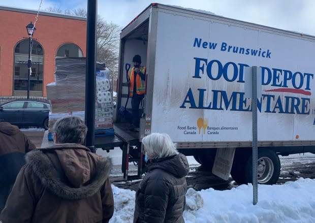 Volunteers line up to lug two pallets of food from Food Depot Alimentaire's truck to the food bank's temporary home. Patterson said even at the regular location, the unloading is done by hand.