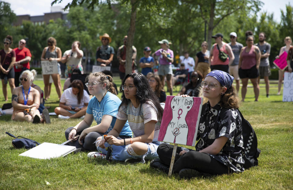 Casper Byrd, right, of Bowling Green, sits with friends as they listen to various speakers share their experiences with abortion and women's rights at the BG Freedom Walkers' protest against the overturning of Roe v. Wade and Kentucky's trigger law to ban abortion, at Circus Square Park in Bowling Green, Ky., Saturday, June 25, 2022. (Grace Ramey/Daily News via AP)