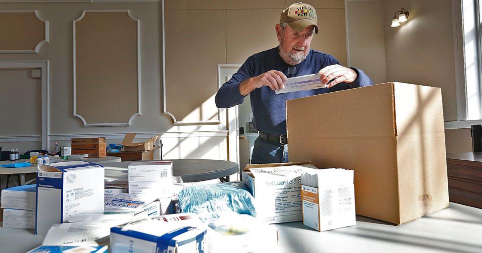 John McDonough, of Quincy, sorts through the hundreds of items, including first-aid kits, disinfectant, pain relievers and medical gloves, that were collected at a supply drive for Ukraine at Braintree Town Hall on Friday, March 11, 2022.