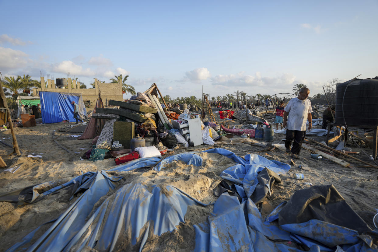 Palestinians look at the destruction after an Israeli airstrike on a crowded tent camp housing Palestinians displaced by the war in Muwasi, Gaza Strip, Tuesday, Sept. 10, 2024. An Israeli strike killed at least 40 people and wounded 60 others early Tuesday, Palestinian officials said. Israel said it targeted "significant" Hamas militants, allegations denied by the militant group. (AP Photo/Abdel Kareem Hana)