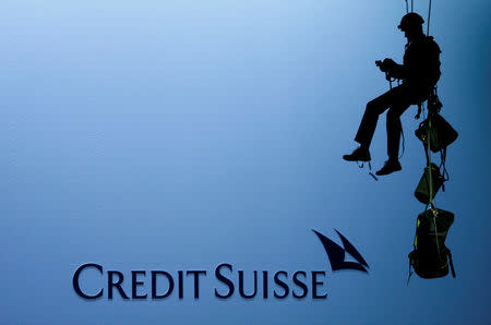 An activist of environmental group Greenpeace is seen beside the logo of of Swiss bank Credit Suisse after unveiling a banner to protest against the financing of the Dakota-Access oil pipeline during the bank's annual shareholder meeting in Zurich, Switzerland April 28, 2017. REUTERS/Arnd Wiegmann