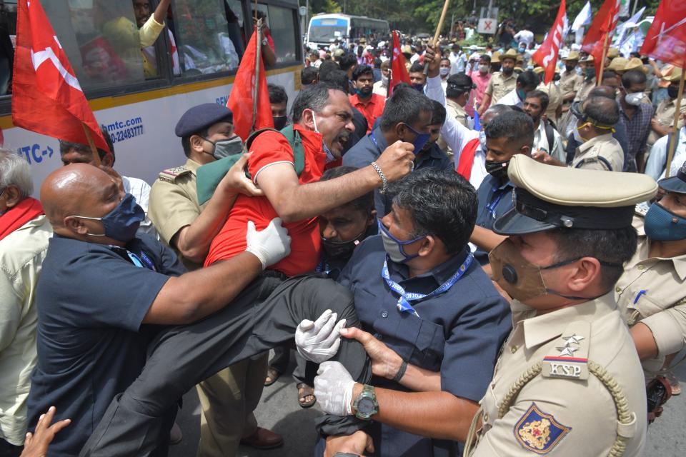 Police personnel detain an activist from a farmers rights organisation during a protest following the recent passing of agriculture bills in the Lok Sabha (lower house), in Bangalore on September 25, 2020. - Angry farmers took to the streets and blocked roads and railways across India on September 25, intensifying protests over major new farming legislation they say will benefit only big corporates. (Photo by Manjunath Kiran / AFP) (Photo by MANJUNATH KIRAN/AFP via Getty Images)