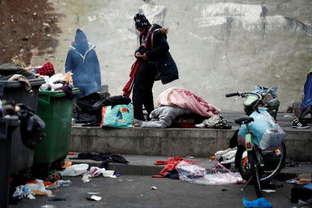 Migrants take their belongings as French police evacuate hundreds of migrants living in makeshift camp set up under the Porte de la Chapelle ring bridge in Paris, France, January 29, 2019. REUTERS/Benoit Tessier