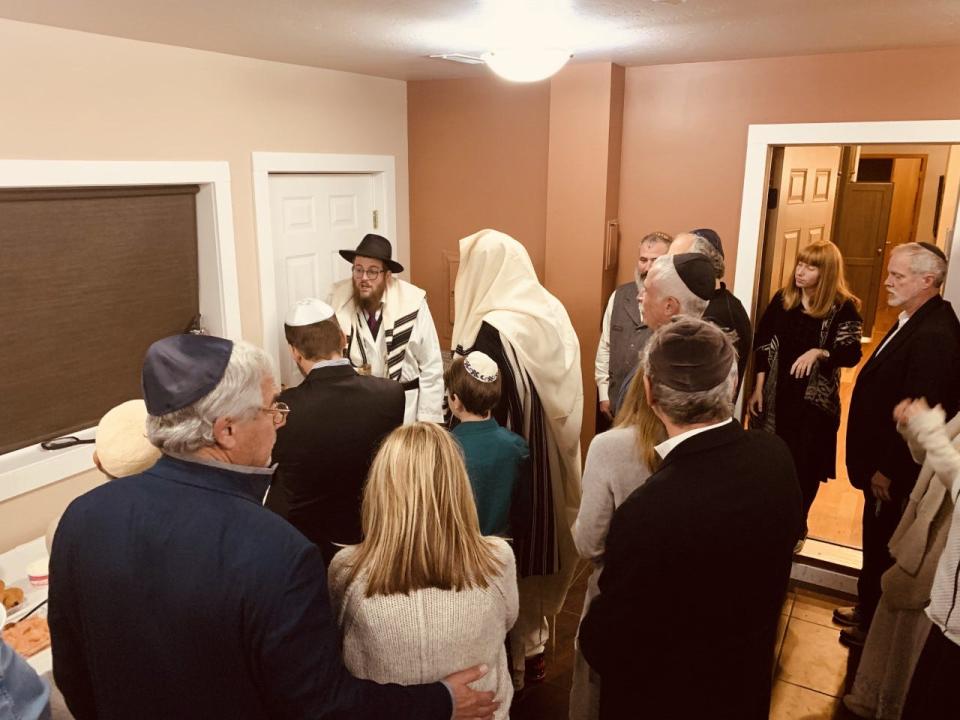 Rabbi Chaim Bruk (back far left in hat) makes the Havdalah service on a glass of wine to celebrate the conclusion of Yom Kippur at his synagogue in Bozeman, Montana.