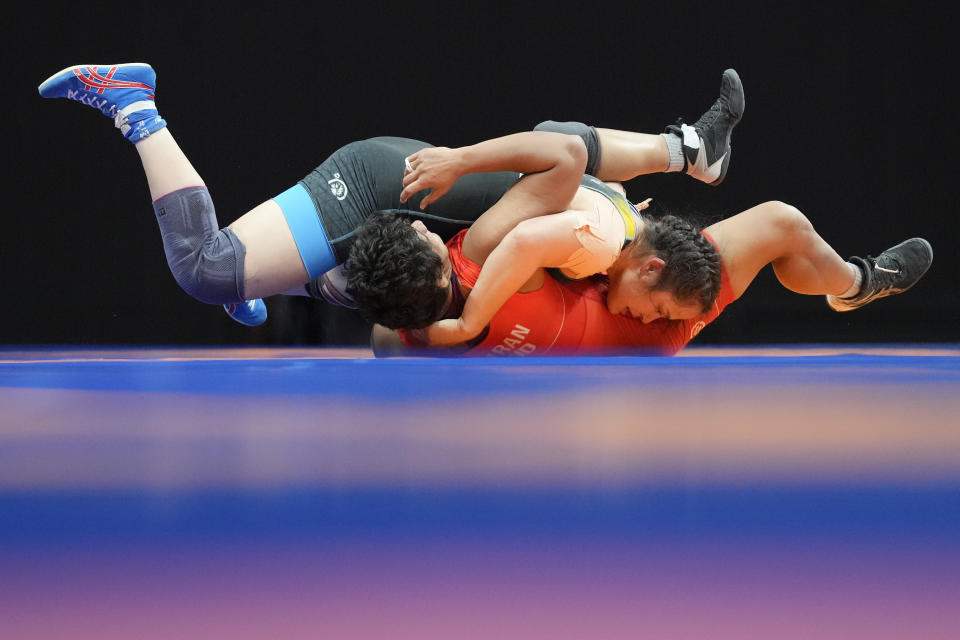 Kazakhstan's Zhamila Bakbergenova, top, and India's Kiran compete during the Women's Freestyle 76Kg wrestling semifinal at the 19th Asian Games in Hangzhou, China, Friday, Oct. 6, 2023. (AP Photo/Aaron Favila)
