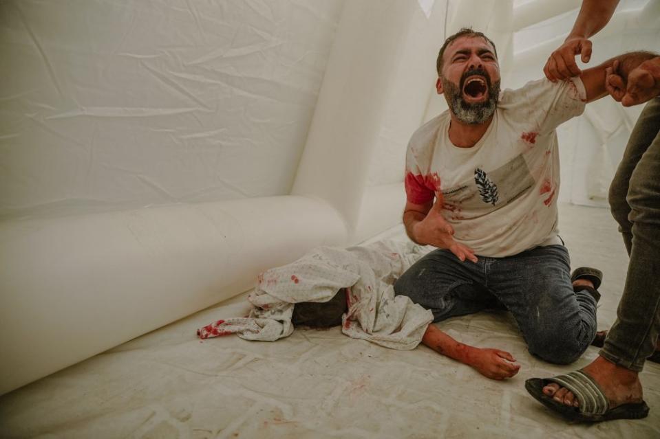 Omar Lafi grieves on Oct. 9 by the lifeless body of his nephew, who was killed by an airstrike.<span class="copyright">Saher Alghorra—Middle East Images/AFP/Getty Images</span>