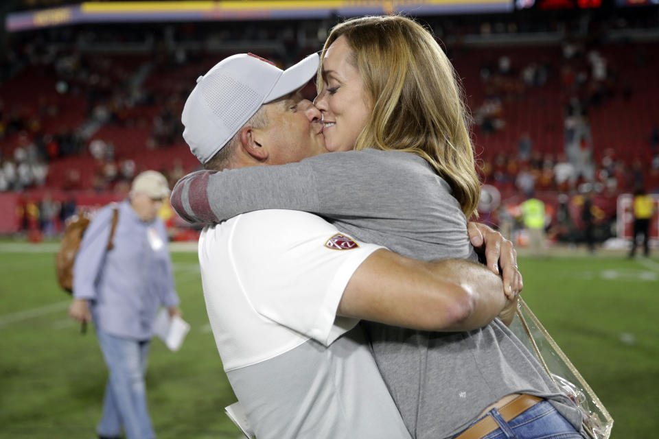 Southern California coach Clay Helton kisses his wife, Angela, after the team's 30-23 win over Utah in an NCAA college football game Friday, Sept. 20, 2019, in Los Angeles. (AP Photo/Marcio Jose Sanchez)