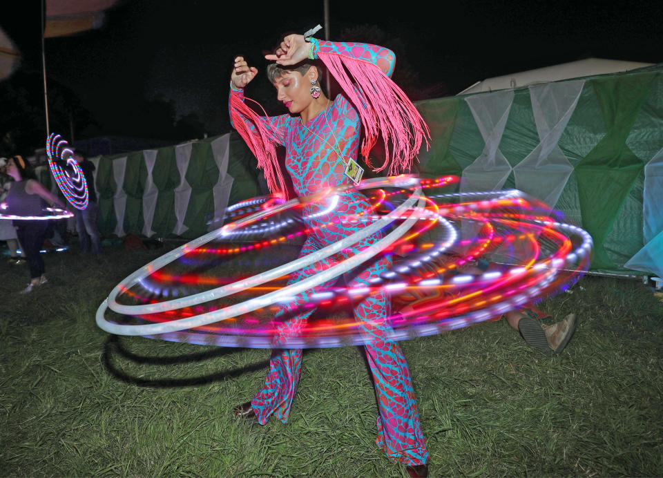 Festival-goer Penelope Gwen performing with an LED hula hoop after dark, at the Glastonbury Festival, Worthy Farm in Pilton, Somerset.