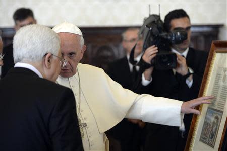 Pope Francis exchanges gifts with Palestinian President Mahmoud Abbas during a private audience in the pontiff library at the Vatican, October 17, 2013. REUTERS/Maurizio Brambatti/Pool